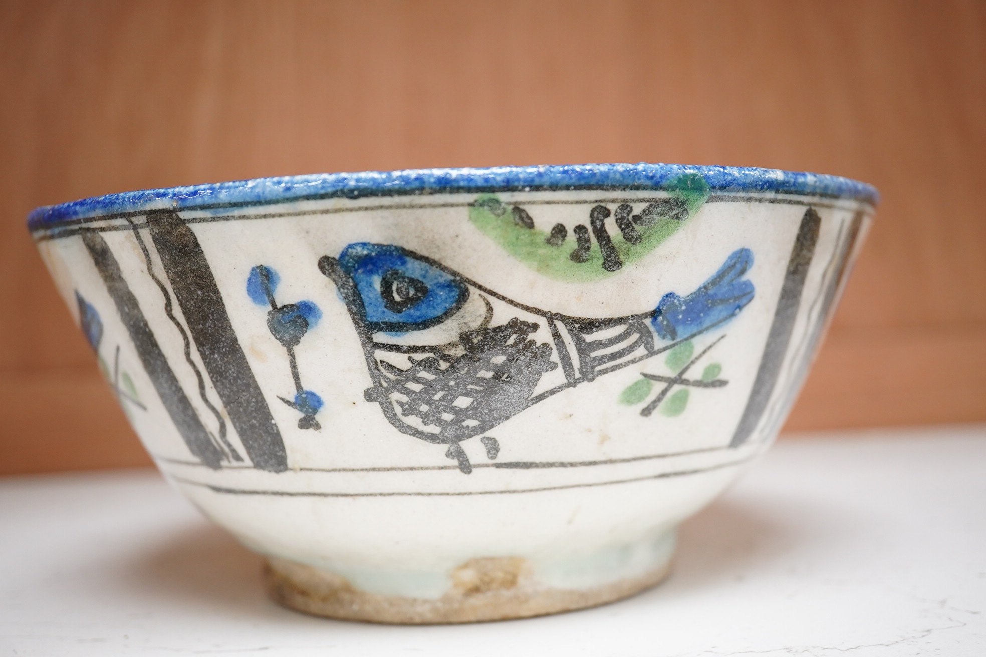 An 18th century Persian pottery bowl with bird decoration, 19cm diameter. Condition - poor